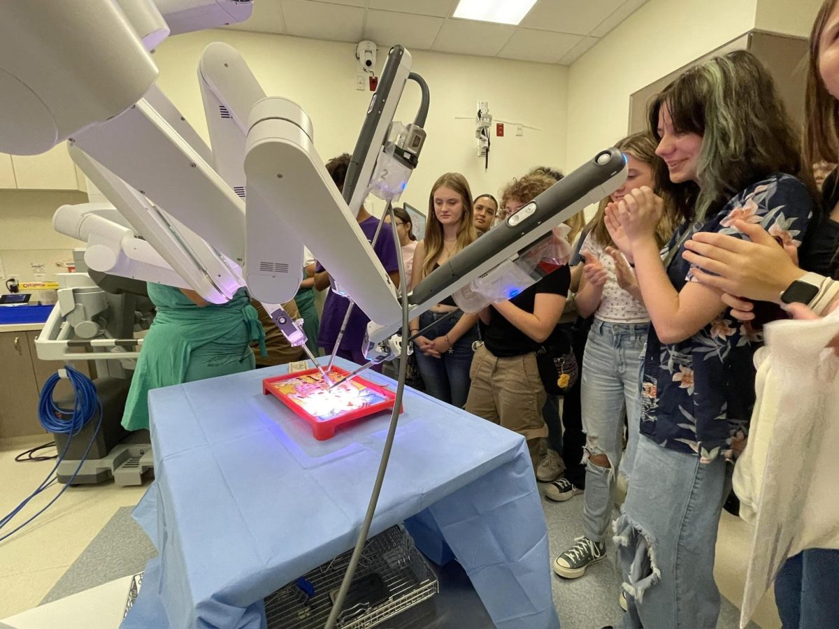 Students gather around the surgery robot for a demonstration.